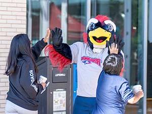 Rowdy slinging high fives to prospective students.